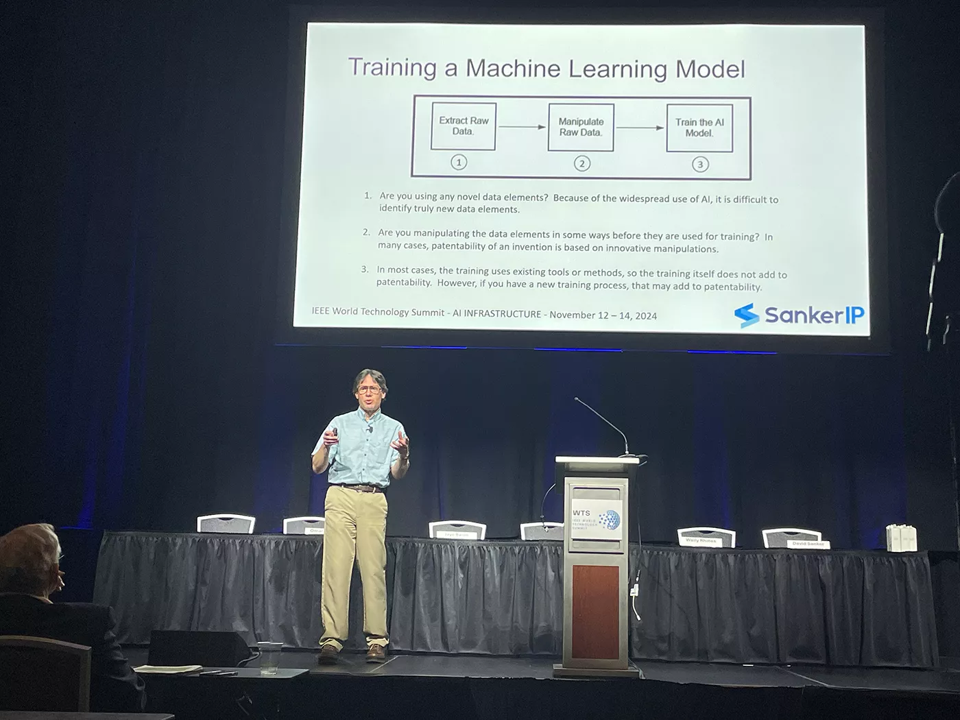 David Sanker presenting on stage at IEEE World Technology Summit on AI Infrastructure