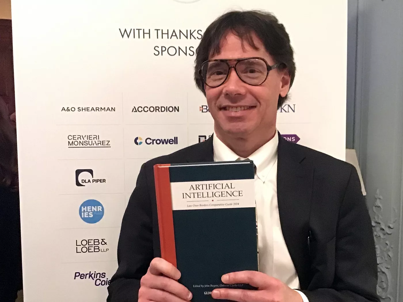 David Sanker holding IA book at a book signing at the Luxury Law Summit event.