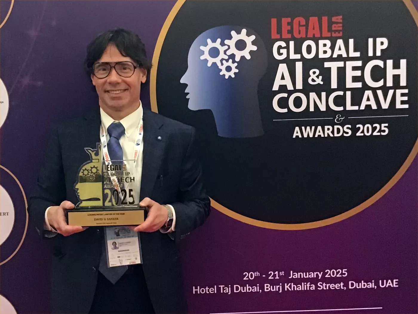David Sanker holding a "Leading patent lawyer of the year" trophy at AI conference in Dubai.