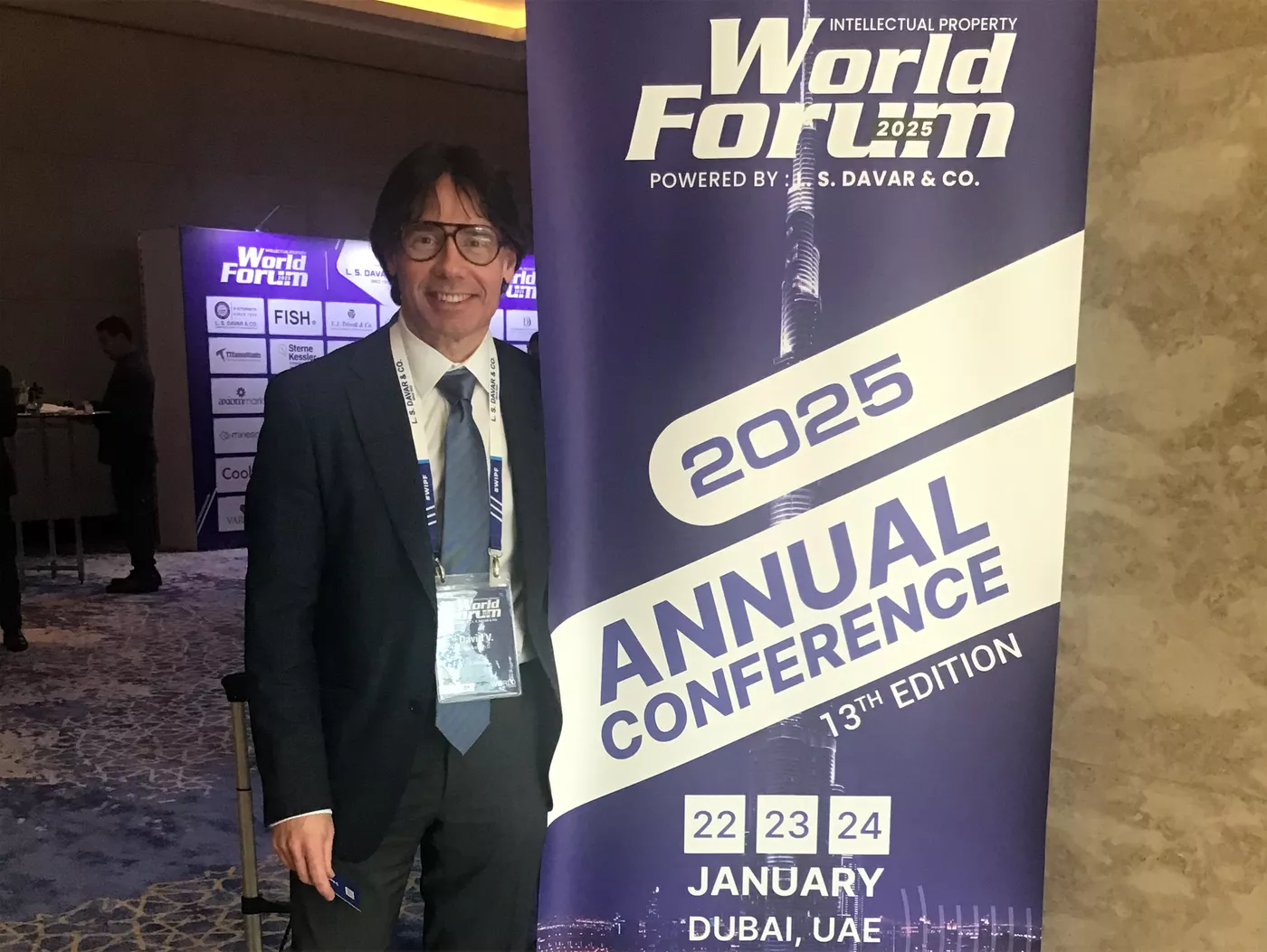 David Sanker standing in front of WIPF sign in Dubai.