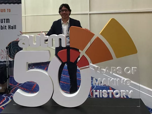 David Sanker standing in front of AUTM sign.